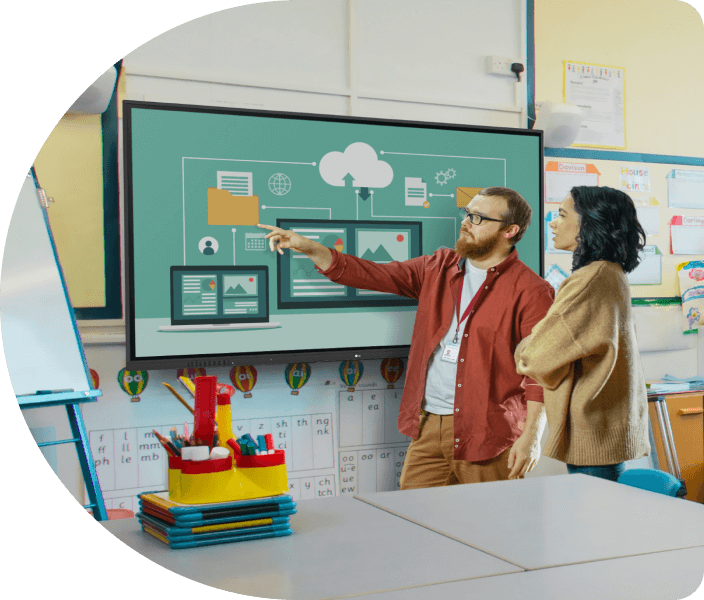 Two teachers looking at a createboard in a classroom