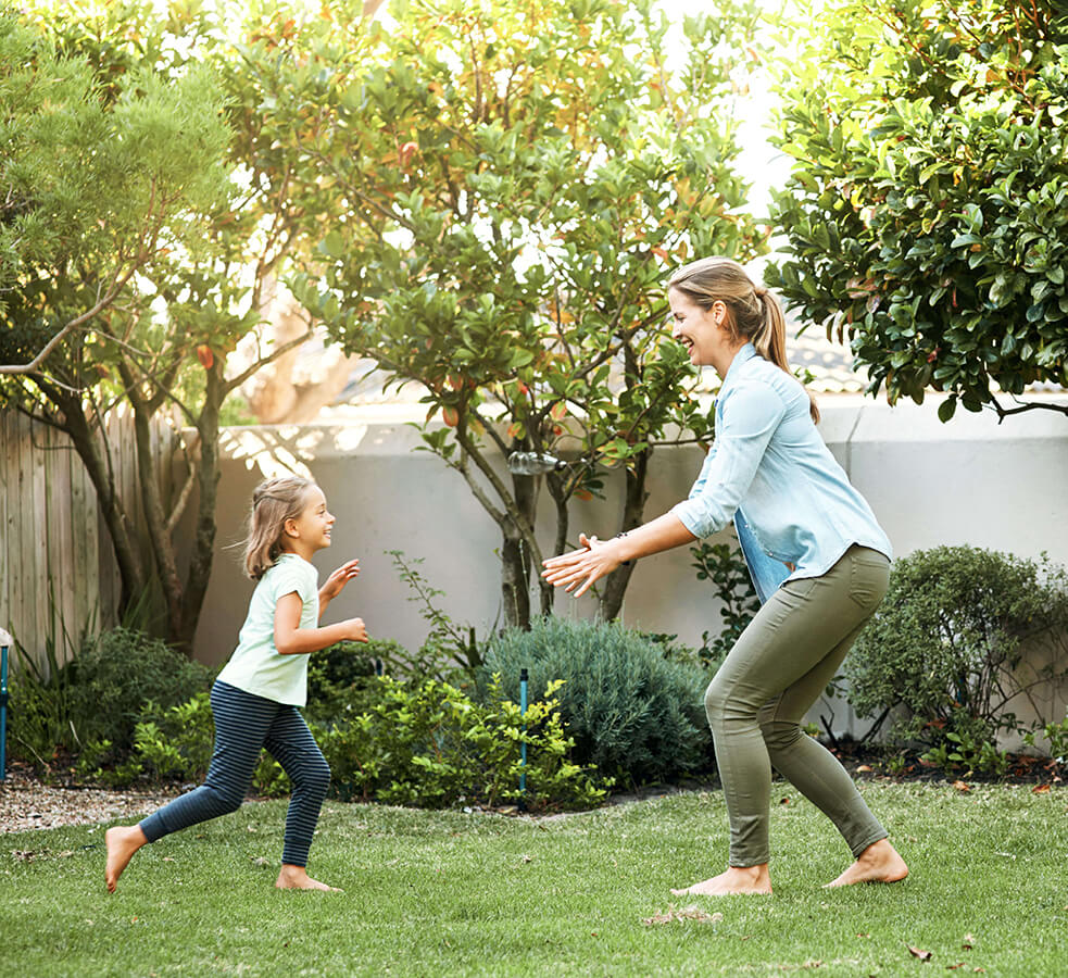 a child running into her mothers arms in a yard